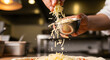© Bayu Tri Nugroho - A chef's hand expertly sprinkles shredded mozzarella cheese onto a delicious homemade pizza, creating a mouthwatering culinary masterpiece in a professional kitchen setting.