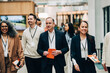 © Maskot - Smiling male and female business professionals at networking event