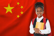 © New Africa - Little girl with backpack and notebooks against flag of China. Language school