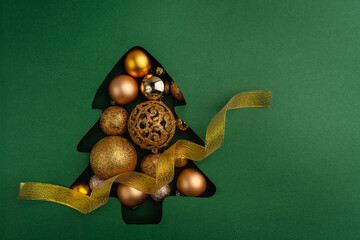 Wall Mural - a collection of gold and bronze christmas baubles arranged inside a green christmas tree cutout, cre