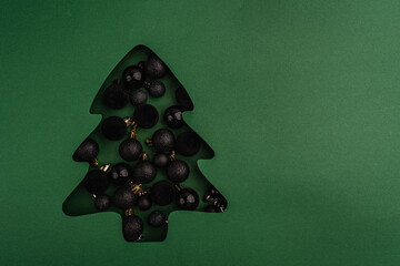 Wall Mural - modern black baubles fill a green christmas tree-shaped cutout, creating a bold, minimalist holiday 