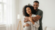© Vasiliy - Pregnant african american woman with partner embracing at home. Happy diverse couple maternity moment for multicultural family planning services