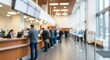 © David Zarzosa - Blurred image of people standing in line at service counter inside modern bank or office hall.