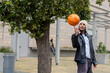 © Wavebreak Media - Male wearing beanie spinning basketball on finger in courtyard with headphones