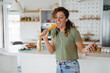 © Dorde - Joyful Young Woman Dancing and Singing in a Bright Modern Kitchen Holding Spaghetti