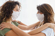 © Dorde - Two Caucasian Female Friends Wearing White Masks Indoors in Bright Natural Lighting