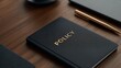© FocusFusion - Notebook Titled Policy Placed on a Wooden Desk With Office Supplies Nearby