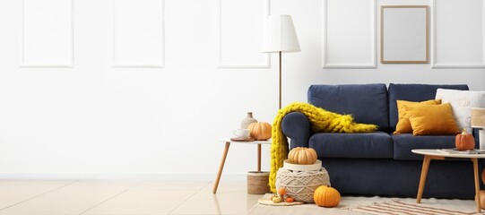 Poster - interior of living room with sofa, tables, pouf, lamp and autumn decorations. banner for design
