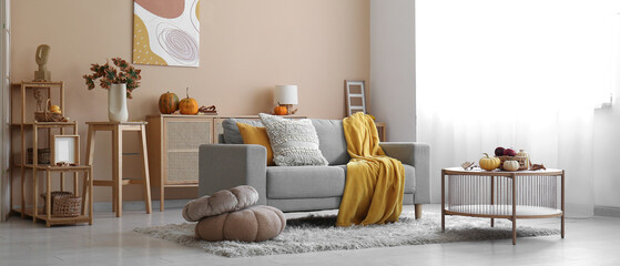 Poster - interior of cozy living room with autumn decor, sofa and table