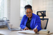 © David - African American business woman, A female secretary work on laptop Sitting at a Desk, reports to the workplace in the office, uses a computer