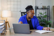 © David - African American business woman, A female secretary work on laptop Sitting at a Desk, reports to the workplace in the office, uses a computer
