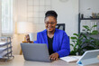© David - African American business woman, A female secretary work on laptop Sitting at a Desk, reports to the workplace in the office, uses a computer