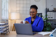 © David - African American business woman, A female secretary work on laptop Sitting at a Desk, reports to the workplace in the office, uses a computer