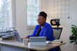 © David - African American business woman, A female secretary work on laptop Sitting at a Desk, reports to the workplace in the office, uses a computer