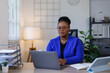 © David - African American business woman, A female secretary work on laptop Sitting at a Desk, reports to the workplace in the office, uses a computer