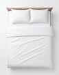 © Growth - Overhead shot of a bed with white linens and two pillows on a white background, featuring a light wood frame. Soft and inviting