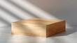 © tai - A wooden rectangular platform on a concrete floor with light shadows, showcasing a minimalist and clean presentation setup.