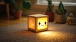 © zeandra - Cute, light-up, wooden cube lamp on a carpet.  Soft, warm light shines from the inside.  Friendly, kawaii face design.  Stars and light-colored patterns on the face.  Surrounded by plants in pots