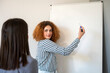© GREGORIO - Young businesswoman writing on whiteboard during a meeting with a colleague
