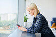 © baranq - Side view of woman in an office using phone