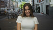 © Krakenimages.com - Woman in white shirt shows teeth while smiling on busy city street lined with bicycles and cars; carefree happiness.