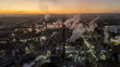 © rafaelnlins - Indústria de papel e celulose vista do alto ao amanhecer, com chaminés soltando fumaça sob o céu dourado, cenário que mistura desenvolvimento e meio ambiente