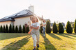 © Maria Vitkovska - Happy children running in the garden of a sustainable house with solar panels