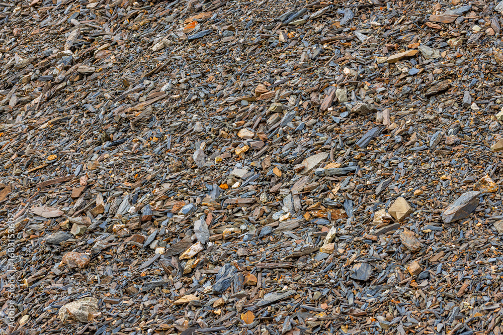 Scattered sharp crushed sedimentary rocks on rocky hillside during ...