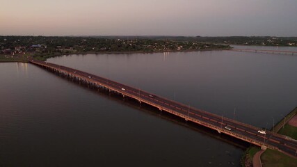 Wall Mural - Aerial footage of the Mboi Ca'e Bridge crossing Parana River, in southern Paraguay at sunset