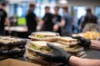 © nia - Hands in black gloves stacking pre packaged sandwiches for catering.