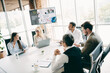 © deagreez - Group of business professionals collaborating in a meeting room during a team conference with a presentation display