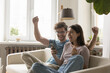 © fizkes - Excited couple in love celebrate victory looking on smartphone screen