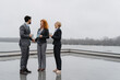 © Novak - Three business colleagues take a break on a rooftop terrace, enjoying tea and coffee. Casual conversation and laughter highlight a relaxed moment during a busy workday.