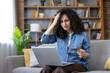 © Liubomir - Stressed woman having problem with online payment using credit card and laptop at home