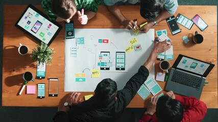 Professional developer team sharing idea of Ux Ui design by using mind map. Top down view of group of business people working together to brainstorm or plan mobile phone interface app. Convocation.