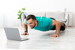 © Prostock-studio - Smiling millennial european male doing push ups and watching online lesson on pc in minimalist living room interior. Workout at home, social distance, coach remotely, gadget and covid-19 lockdown