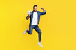 © Prostock-studio - Saving money, gambling, gaming, trading, loan concept. Positive middle-eastern guy holding bunch of money and raising fist up, won lottery, yellow studio background, full length, copy space