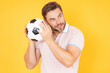 © Volodymyr - Man hold football ball. Sport victory. Excited man holding soccer ball in studio. Football fan showing football ball. Soccer fan. Supporter celebrating football success. Big sport lottery win.