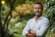 © Praveen - Confident man stands with arms crossed in a park, exuding self-assurance and strength in a calm and peaceful environment, Generative AI