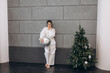 © kuzmichstudio - Beautiful fashionable brunette model woman in white jeans and blouse at Christmas