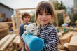 © LimeSky - Grinning girl in a plaid shirt holds a large blue stuffed toy while constructing a tower with an adorable boy