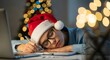 © ENDRA - Tired person wearing a santa hat sleeping at a desk with a laptop and christmas tree in the background, working late on holiday