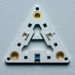 © STK - Close up view of a metallic triangular component featuring gold circular inserts and a central blue element against a light gray background.