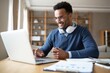 © Meea - Man working from home on laptop computer with headphones and documents on desk happy face