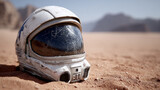 Astronaut helmet on a sandy desert surface.
