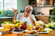 © StockImageFactory - Happy senior Indian foodie enjoying snack-filled table in stylish kitchen setup