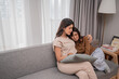 © Odua Images - Two close friends share a tender moment on a cozy sofa, embracing the warmth of their bond