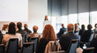 © kasto - Female speaker giving a talk on corporate business conference. Unrecognizable people in audience at conference hall. Business and Entrepreneurship event