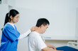 © Nuttapong punna - Healthcare professional assists senior man with shoulder stretch therapy. Ideal for rehab, physiotherapy, aging wellness, pain treatment, and medical care concepts.