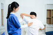 © Nuttapong punna - Nurse provides back massage to senior patient in clinic. Perfect for physiotherapy, rehabilitation, aging care, wellness, pain relief, and professional healthcare themes.
